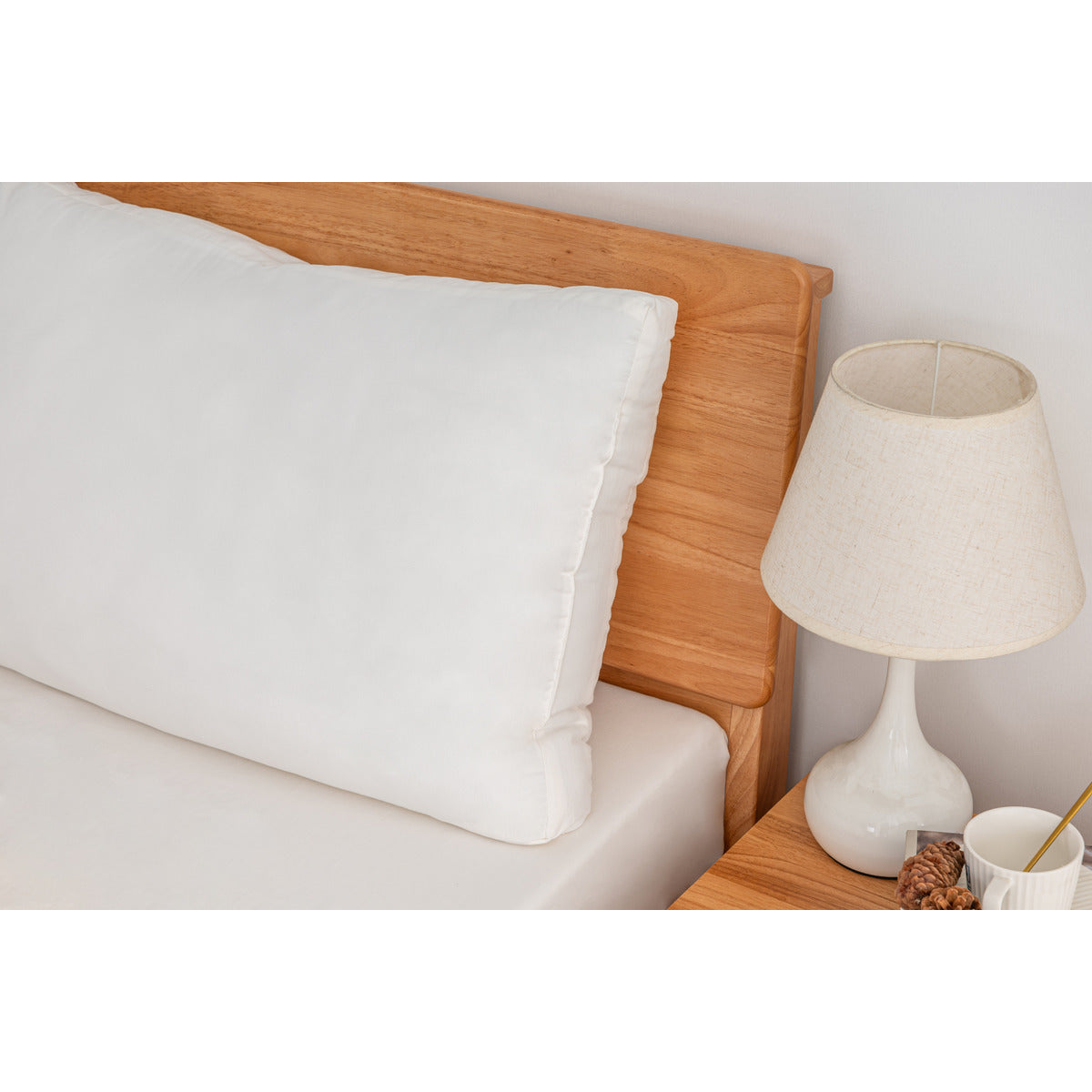 Close-up of one MLILY Soft Washed Down Alternative Pillow, highlighting its breathable design, propped up on a neatly made bed in a decorated bedroom.