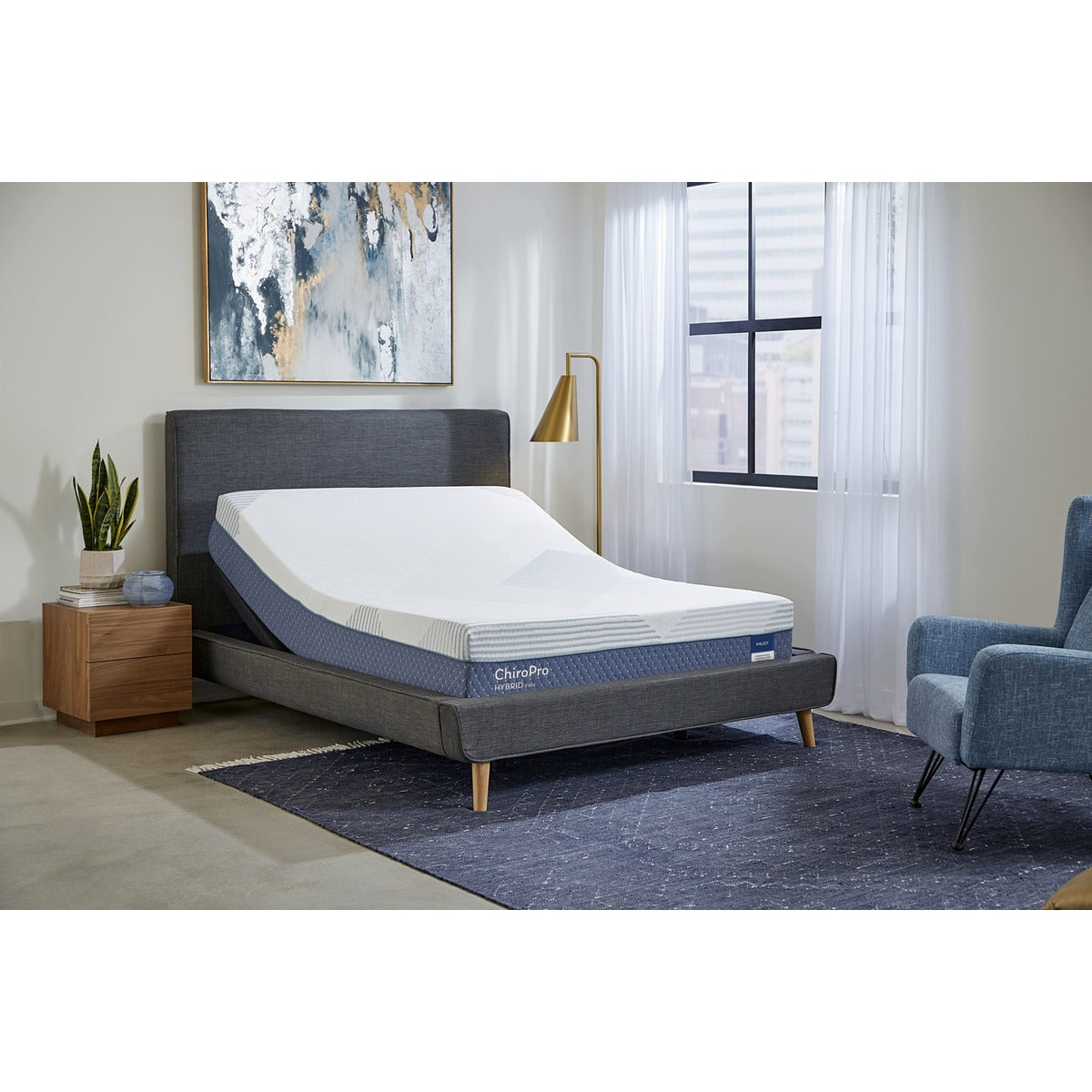 MLILY ChiroPro Hybrid Firm 13" Mattress with the head raised on an adjustable base inside a bedroom, with sunlight shining in from a window.