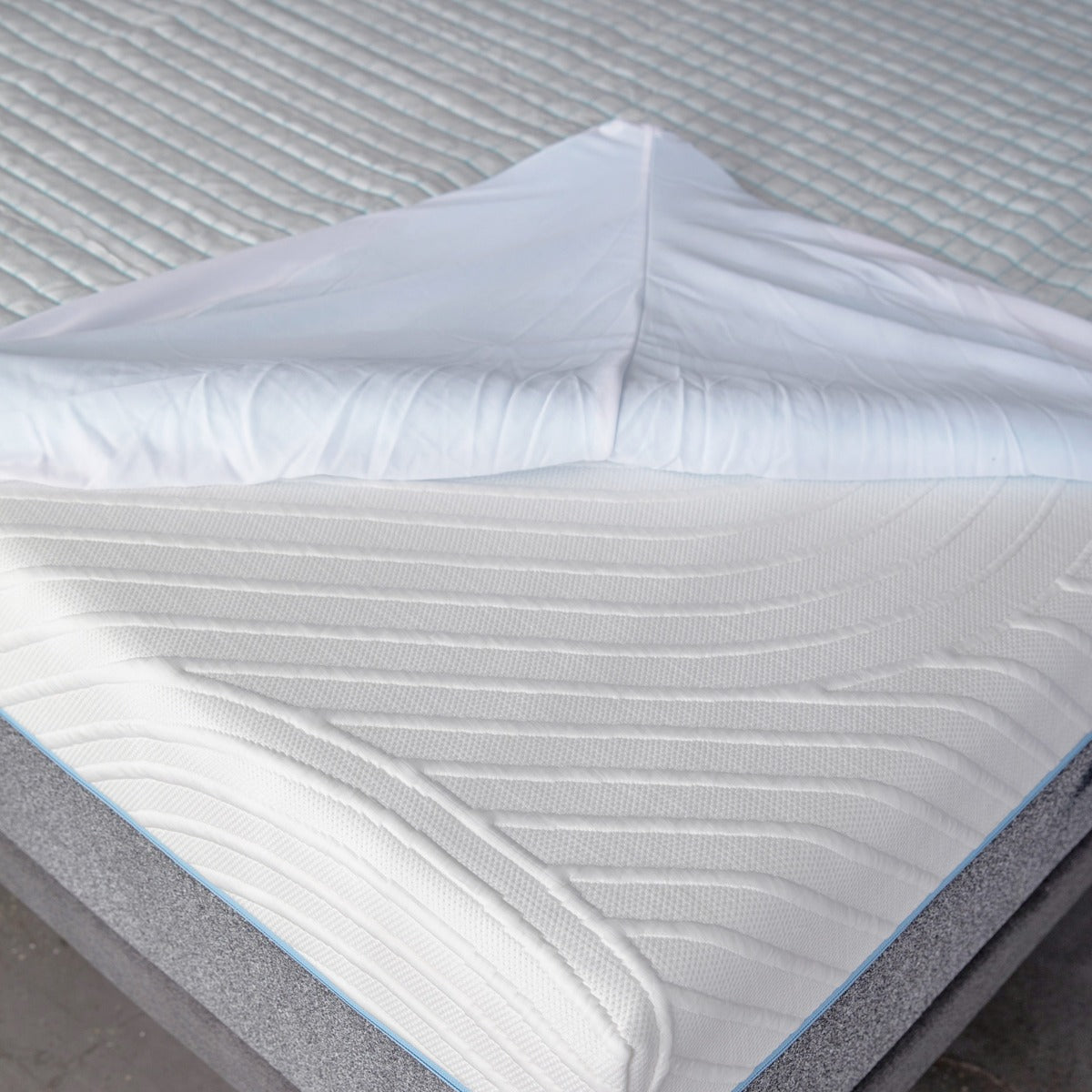 MLILY Cooling Ice Fiber Mattress Protector halfway installed on a mattress, fitting like a fitted sheet. The image shows how the protector snugly covers the mattress, offering protection while demonstrating its easy application.