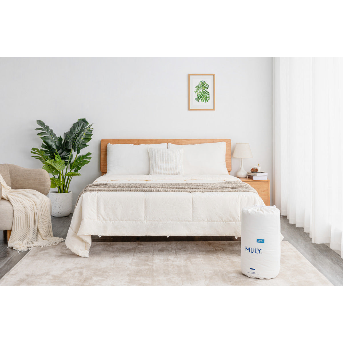 MLILY Eco Soft Duvet Insert spread across a mattress on a platform bed frame, with three pillows at the head and duvet packaging at the foot of the bed in a decorated bedroom.