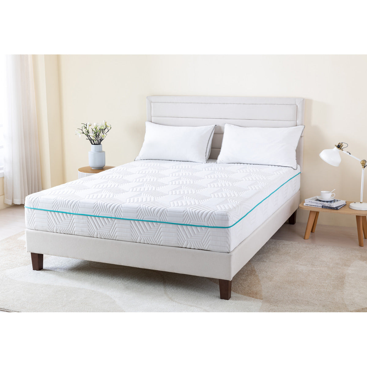 MLILY Essential Plus Memory Foam Medium 10" Mattress viewed from a corner angle, showing the front and side of the mattress, sitting on a platform bed frame with two pillows at the head of the mattress, inside a decorated bedroom.