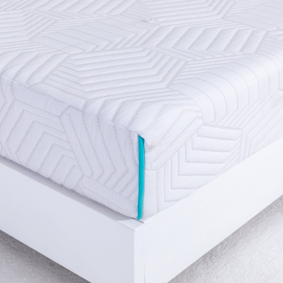 MLILY Essential Plus Memory Foam Medium 8" Mattress showing a corner view, zoomed in to highlight the detail of the mattress cover, sitting on a platform bed frame with carpet flooring inside a bedroom.