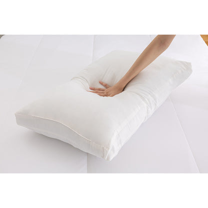 MLILY Soft Washed Down Alternative Pillow laying on a mattress, with a woman's hand pressing down to demonstrate its extra soft and durable design.