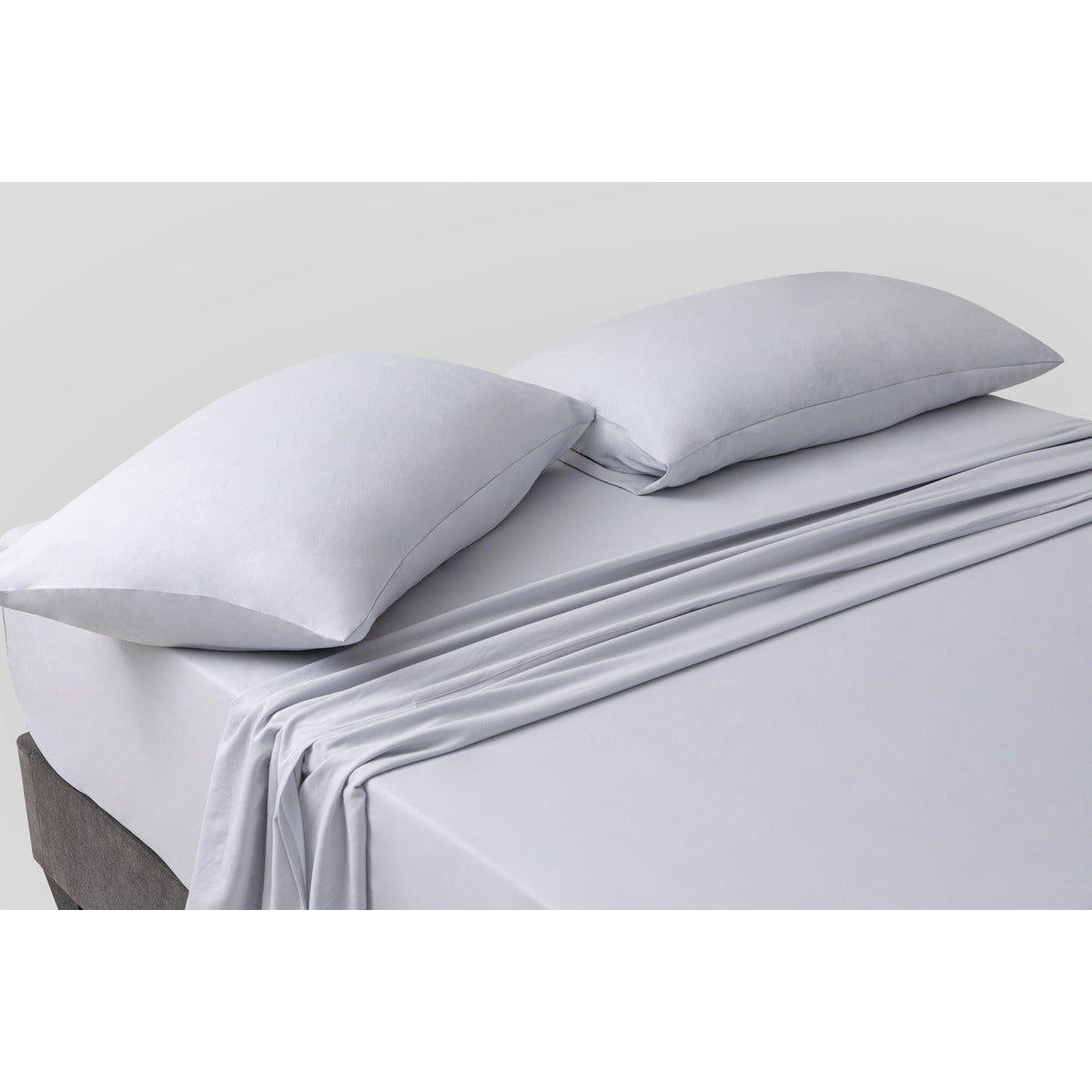 MLILY Soft Washed Sheet Set, close corner slight aerial view, bed made, white background, showcasing the soft and comfortable materials.