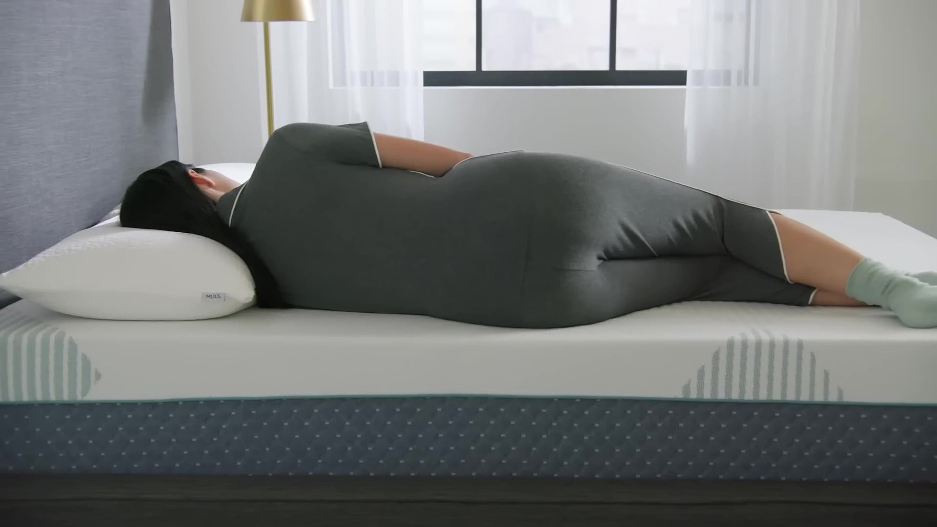 MLILY ChiroPro Hybrid Firm 13” Mattress shown with a woman testing its firmness by feeling the surface, resting on it, and using it with an adjustable base. The mattress adapts to her body for personalized support.